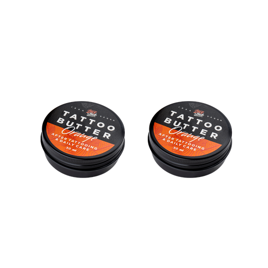 Two tins of Love Ink Tattoo Butter Orange on a transparent background. Both tins are labeled 'Tattoo Butter Orange' for after tattooing and daily care, and each contains 50 ml.